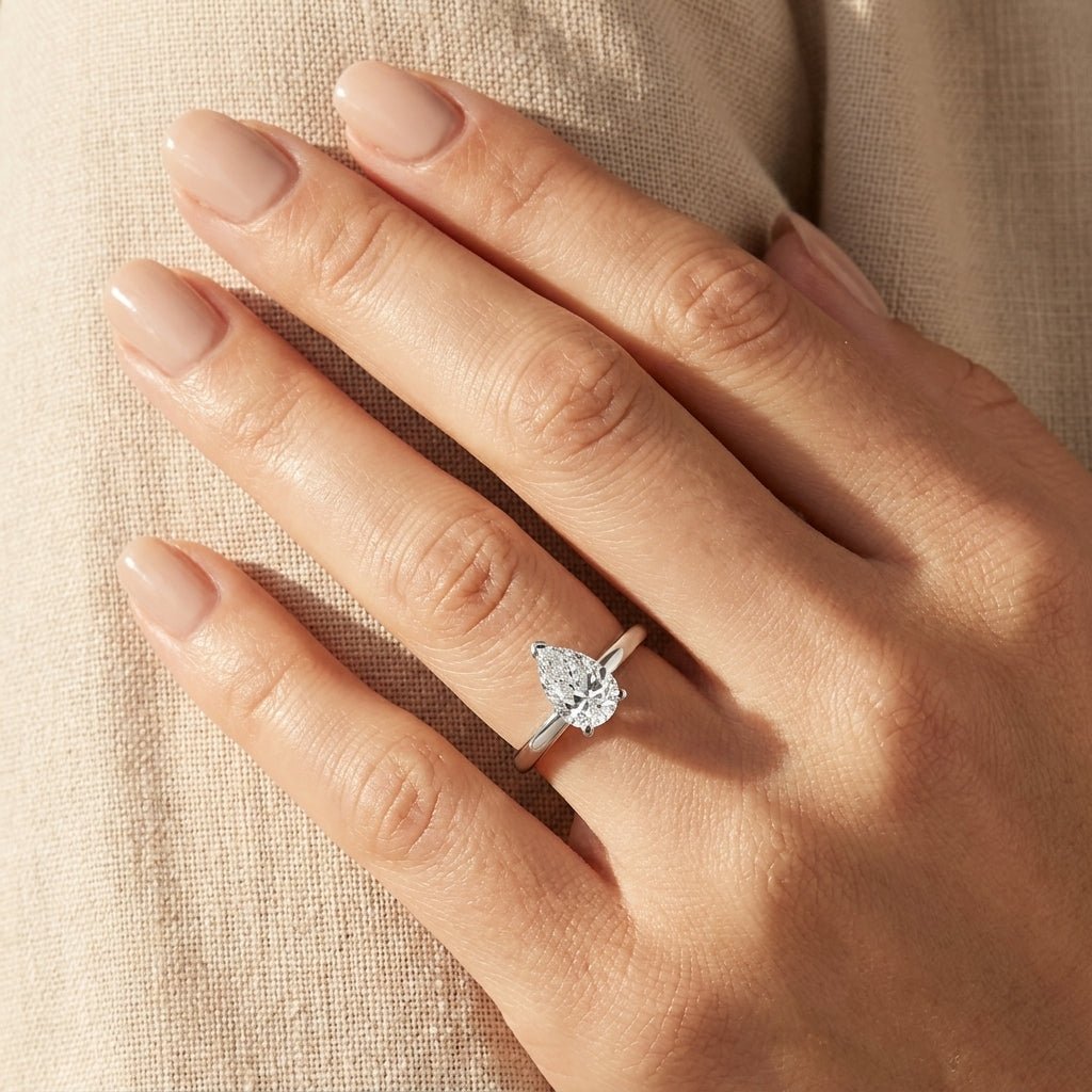 SOL-100PE-0WLD Pear solitaire engagement ring hand-model