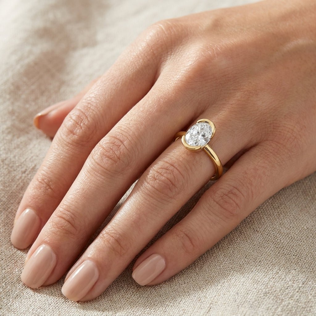 RM12973-200-LD Oval half-bezel engagement ring hand-model
