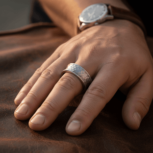 DECIUS — Lifestyle photo on hand — men's tungsten wedding ring.