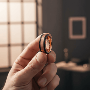 DREAMFLARE — Held between fingers close-up — men's tungsten wedding ring.