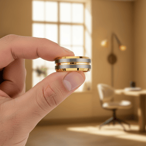 GLEAMLINE — Held between fingers close-up — men's tungsten wedding ring.