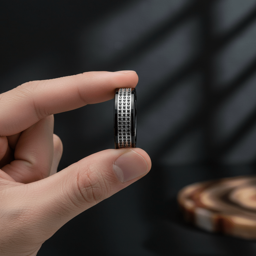 GRAVEL — Held between fingers close-up — men's tungsten wedding ring.