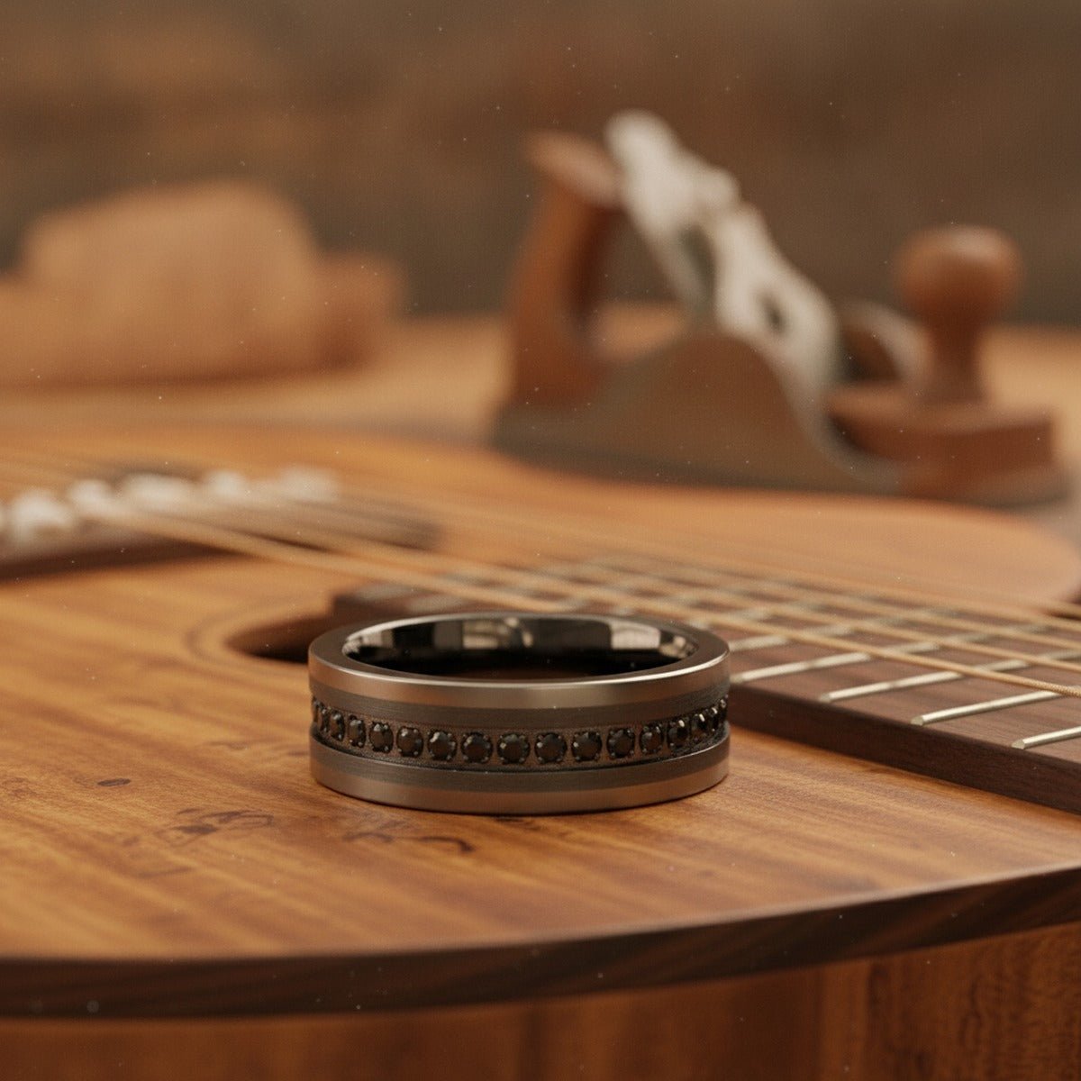 Aydins INFINITUM | Gun Metal Tungsten Ring, Black CZ Eternity, Flat lifestyle scene, luthier shop