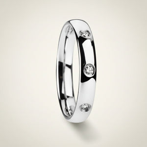 ISABELLA domed white tungsten wedding band with three small diamond accent stones set in a row on the center of the band and polished edges, studio hero shot