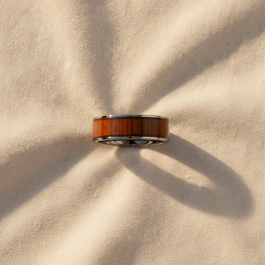 KALANI flat black tungsten carbide wedding band with koa wood inlay running around the band and polished edges macro detail overhead flat lay