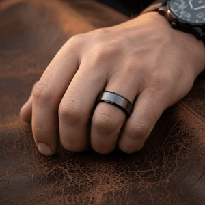 LOVELL — Lifestyle photo on hand — men's tungsten wedding ring.