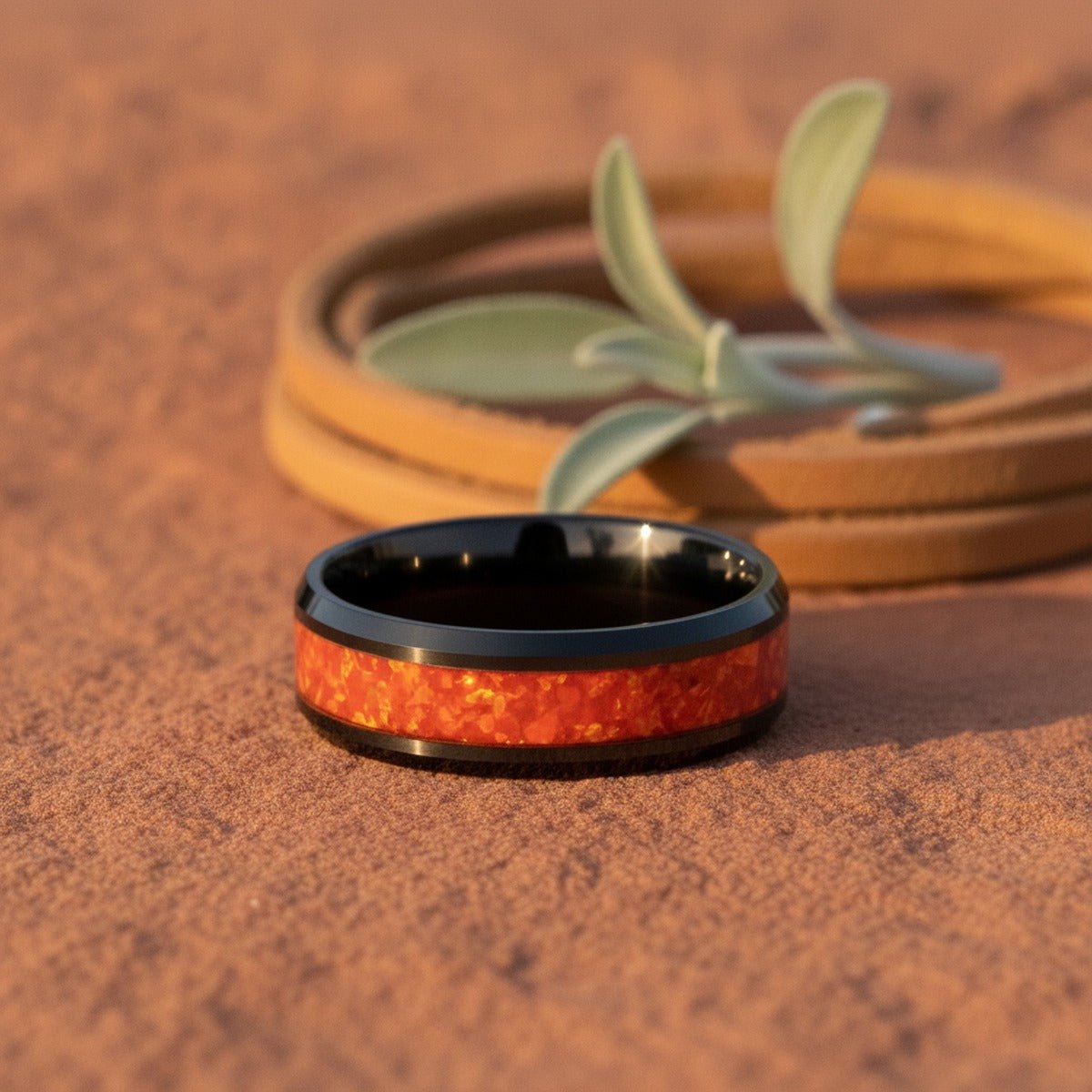 Aydins MAGICA | Polished Black Tungsten Red Fire-Opal Domed Wedding Ring 8mm lifestyle scene, red canyon rock