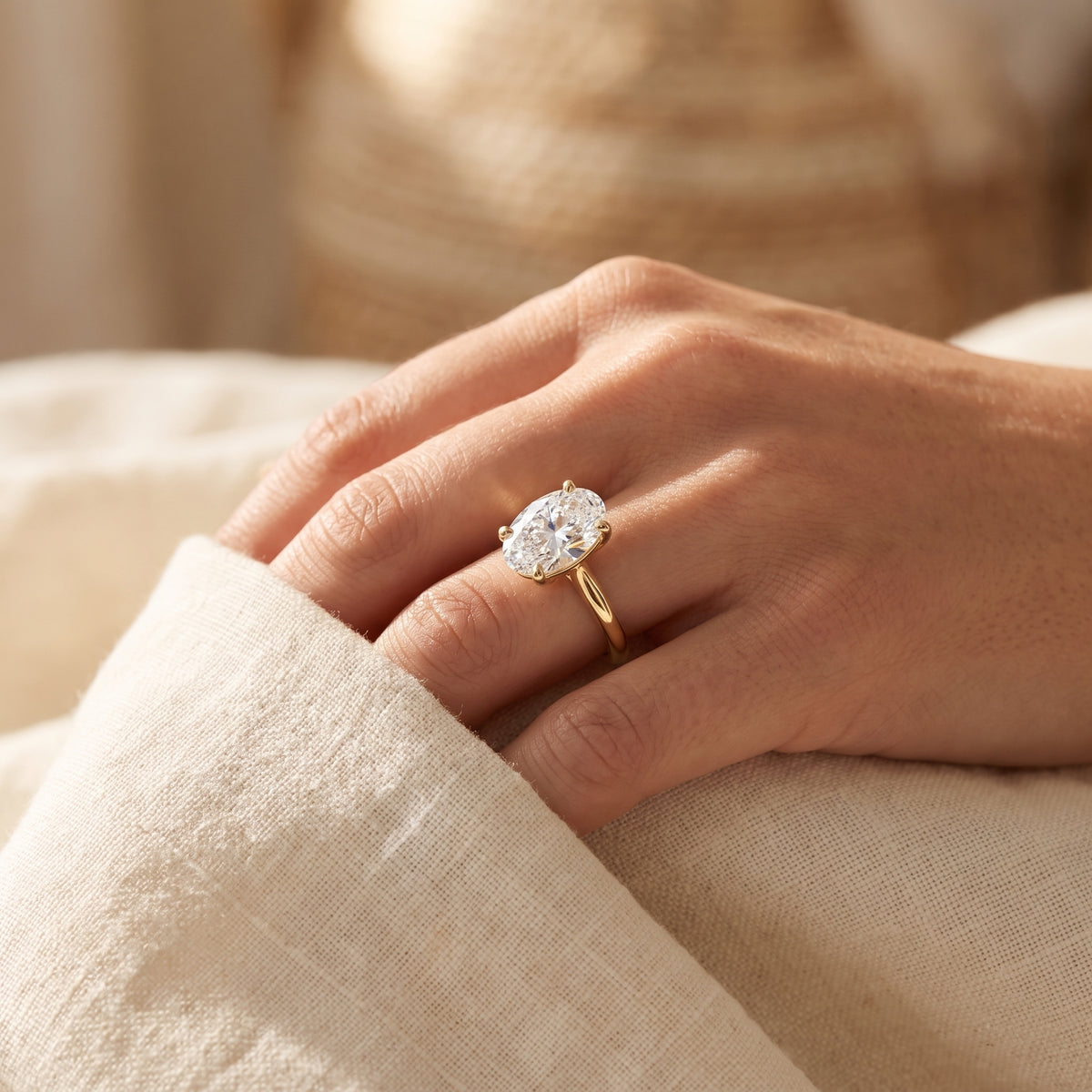 Oval lab-grown diamond solitaire engagement ring, Yellow Gold, lifestyle photograph