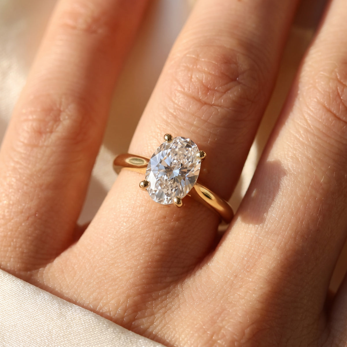 Oval lab-grown diamond solitaire engagement ring, Yellow Gold, on-finger close-up
