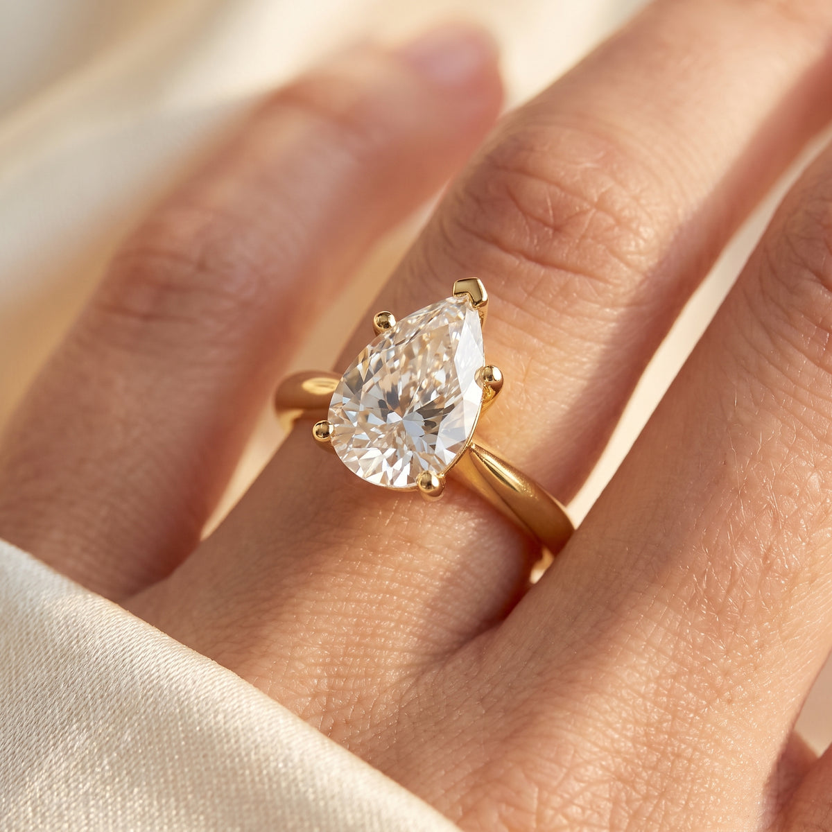 Pear lab-grown diamond solitaire engagement ring, Yellow Gold, on-finger close-up
