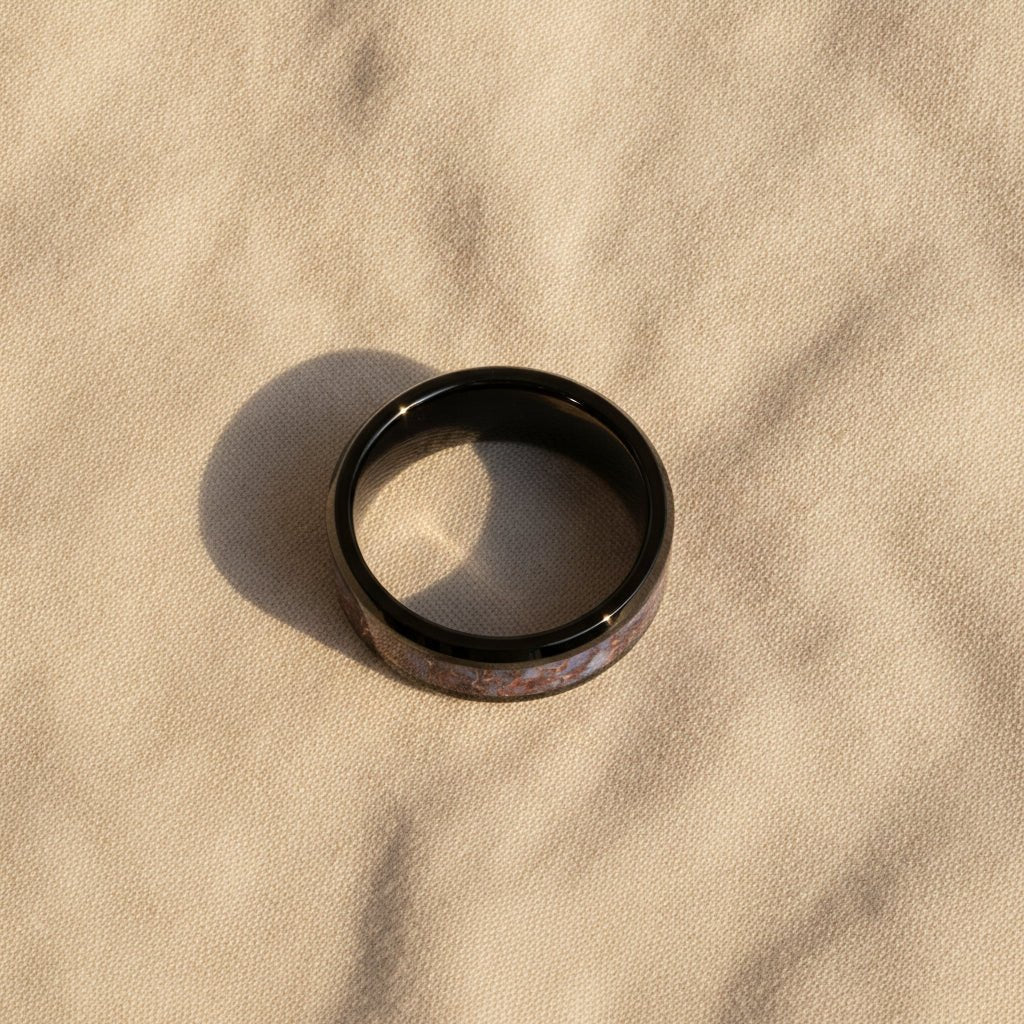 PERMIAN black ceramic ring with blue dinosaur bone inlay running around the band and polished beveled edges macro detail overhead flat lay