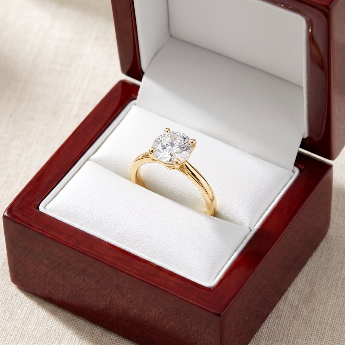 Round lab-grown diamond solitaire engagement ring, in Yellow Gold, shown inside an open cherry-wood ring box