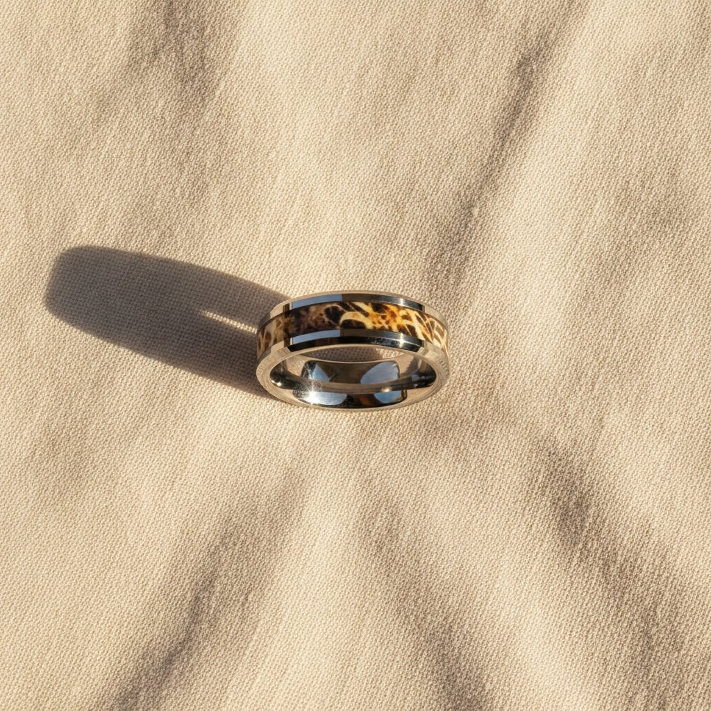 TERRA silver tungsten carbide wedding band with leaves and grassland woodland camouflage inlay running around the band and polished edges macro detail overhead flat lay
