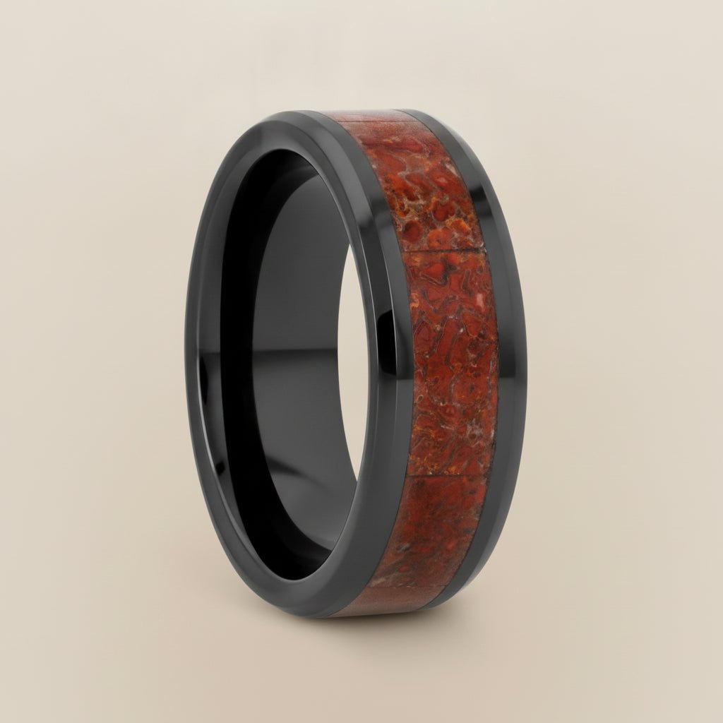 TRIASSIC black ceramic ring with red dinosaur bone inlay running around the band and polished beveled edges, studio hero shot