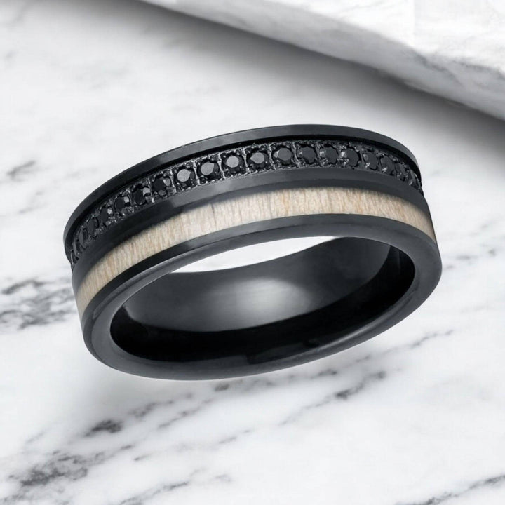 Close-up of black diamond-simulated eternity channel and white wood inlay on tungsten ring.