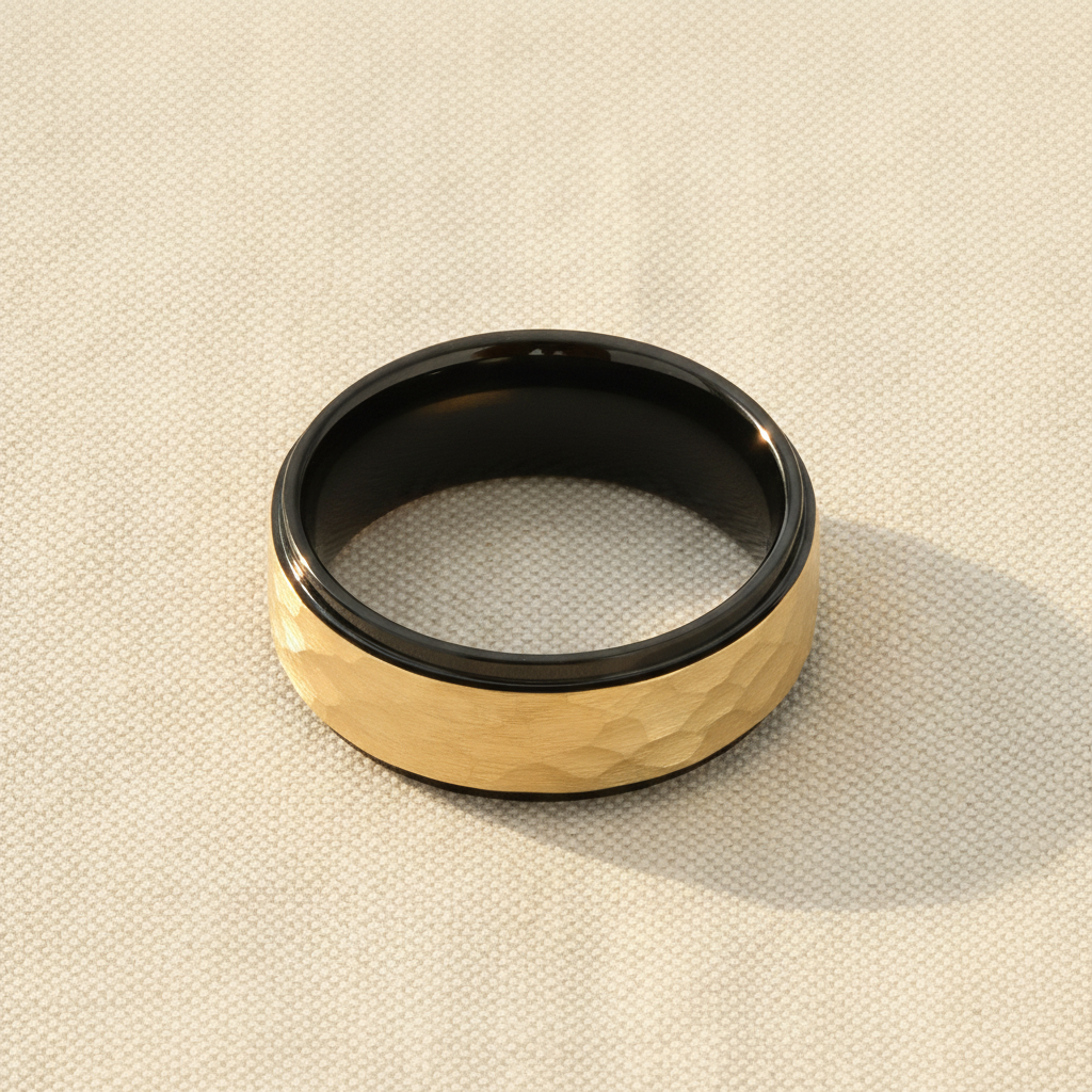 CREED black tungsten wedding band with raised hammered gold-plated finish macro detail overhead flat lay