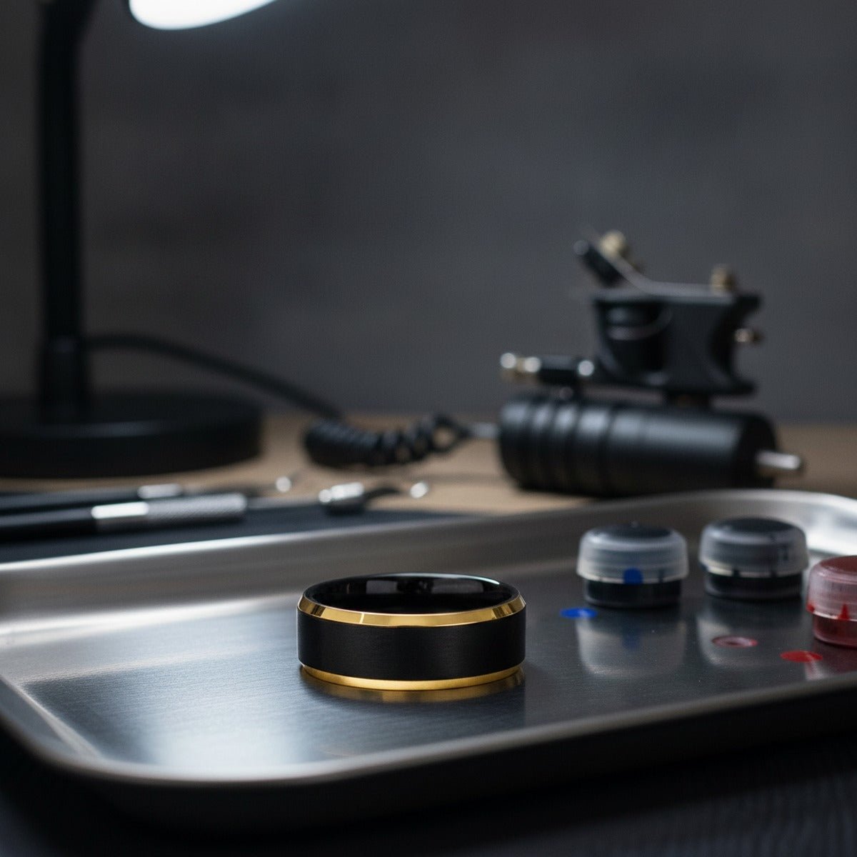Aydins AERGLO | Black Ring Yellow Gold Brushed Center Beveled Edge at the Ring, 6MM lifestyle scene, tattoo studio