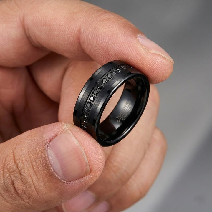 Man hold ring between two fingers a Matte Black APODIS Tungsten Ring - Flat Eternity Band with Black Diamond Stimulants