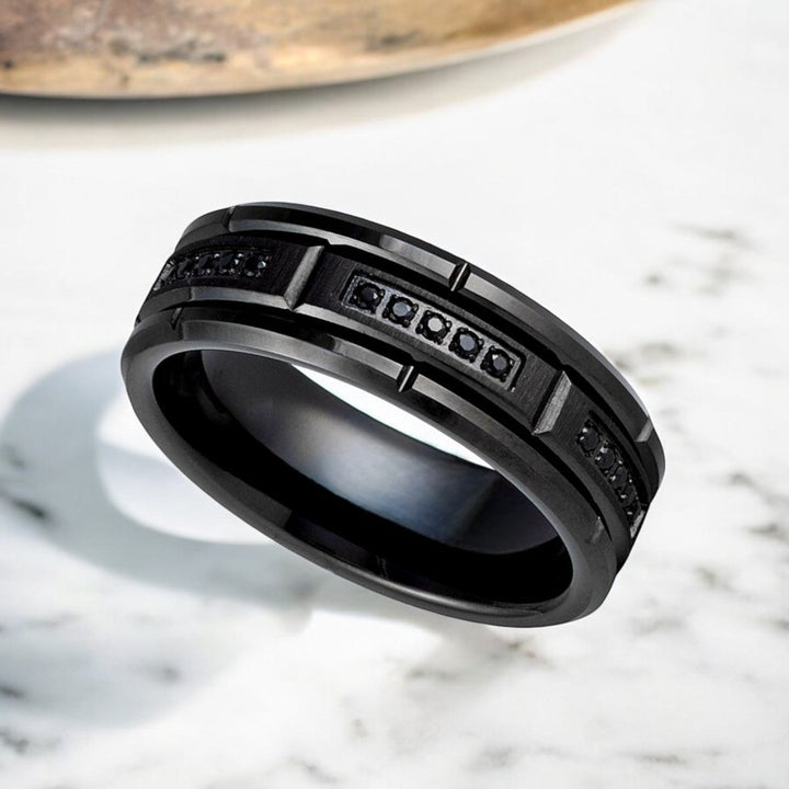 Detailed view of ARKOS tungsten band featuring black diamond-stimulated CZ inlays.