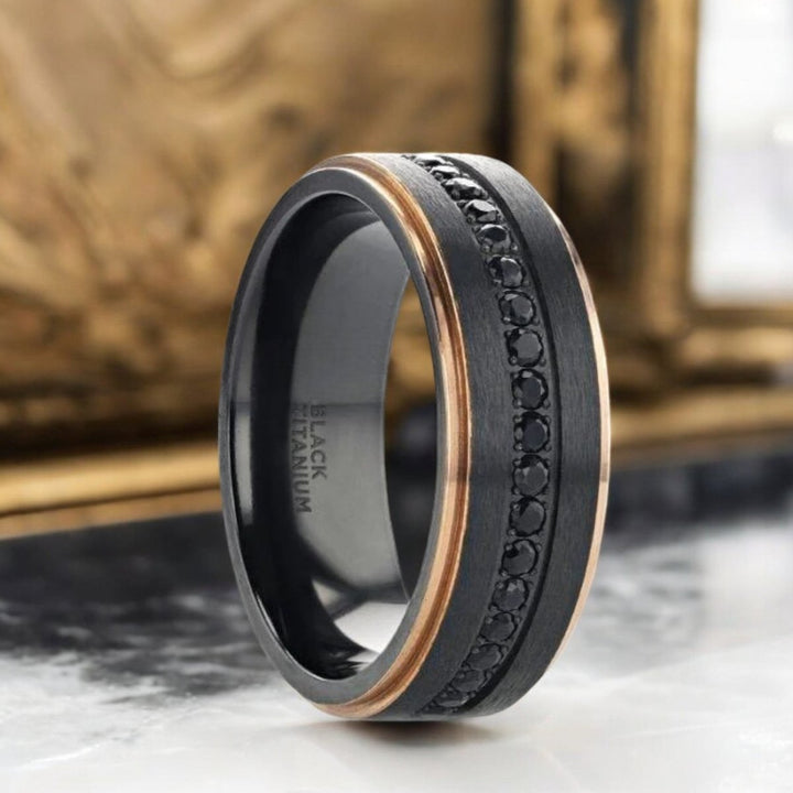 Flat black titanium ring with rose gold edges and black sapphire settings, 8mm width - Aydins Jewelry.