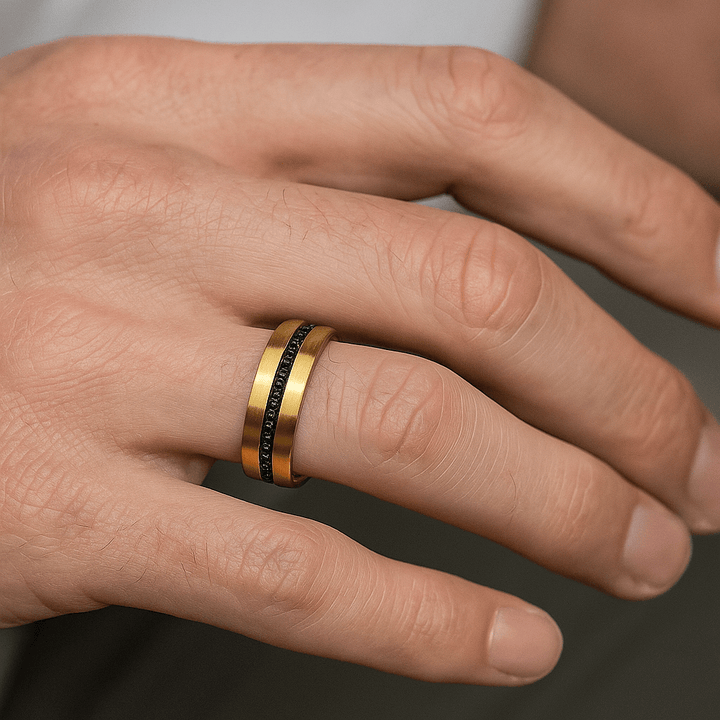 Close-up of black sapphire inlay in brushed gold tungsten band on ring finger