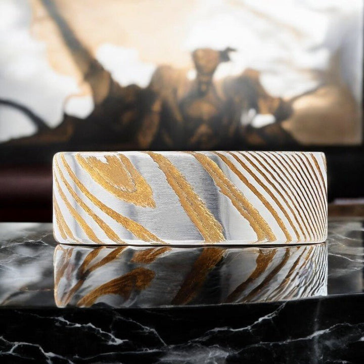 Flat brushed finish of BISHOP gold Damascus steel men’s wedding band.