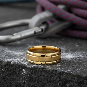 Aydins BRICKCRAFT | Polished Yellow Gold Tungsten Brick Pattern Flat Wedding Ring 8mm lifestyle scene, climbing chalk