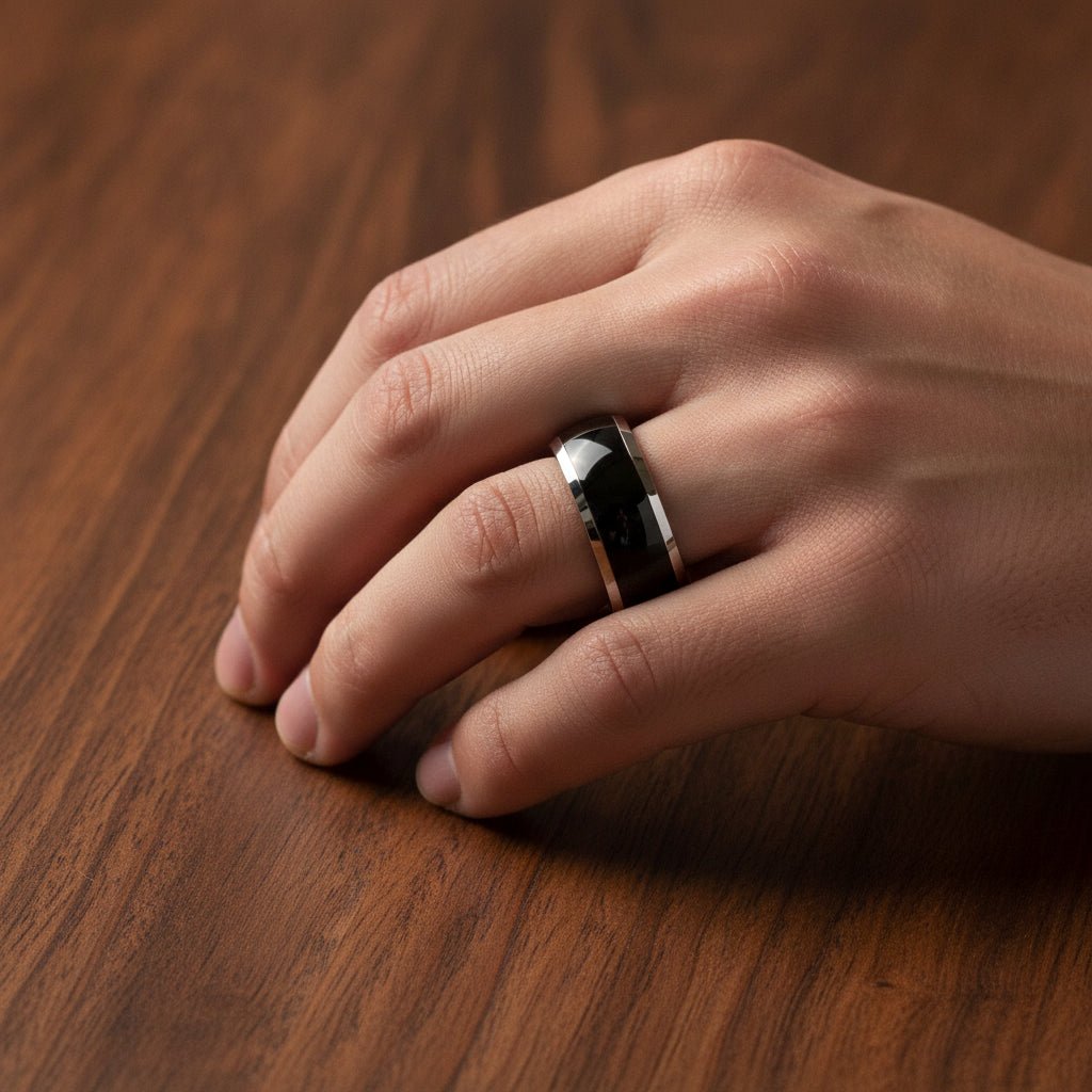 CARRERA black ceramic men's wedding band worn on man's hand resting on walnut wood, lifestyle photo