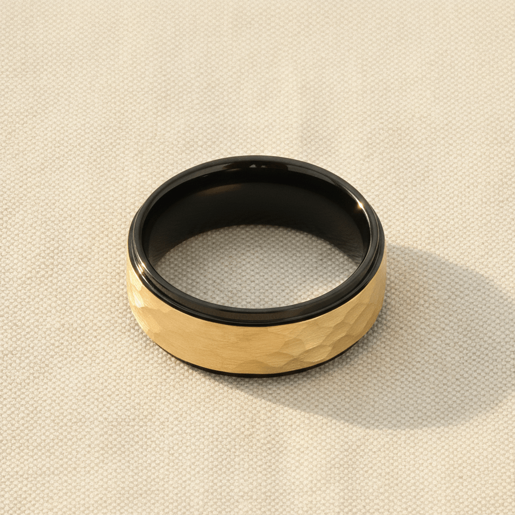 CREED black tungsten wedding band with raised hammered gold-plated finish macro detail overhead flat lay