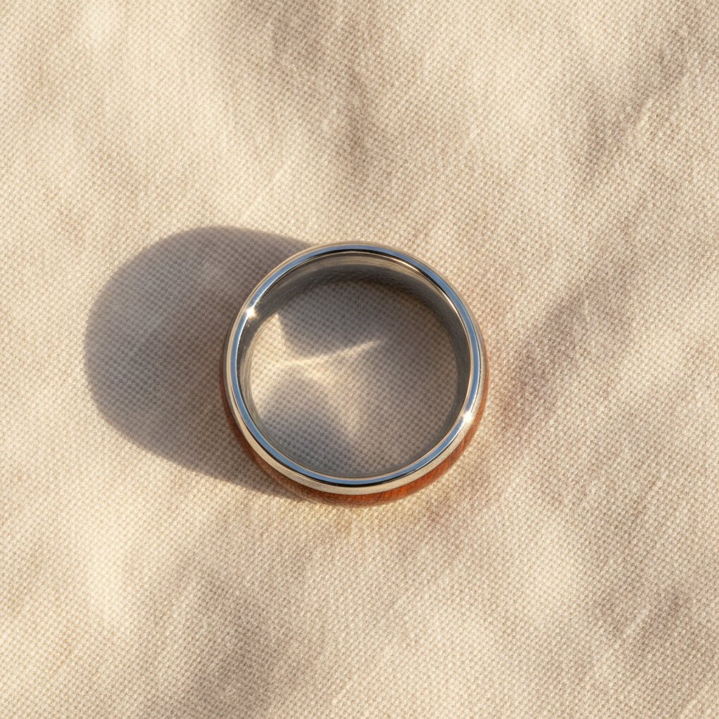DALBERG silver tungsten carbide domed wedding band with rosewood inlay running around the band and polished finish macro detail overhead flat lay