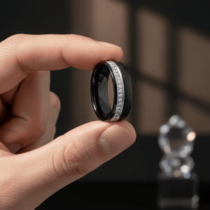 DAZZEL — Held between fingers close-up — men's tungsten wedding ring.