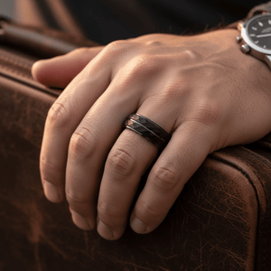DEIMOS — Lifestyle photo on hand — men's tungsten wedding ring.