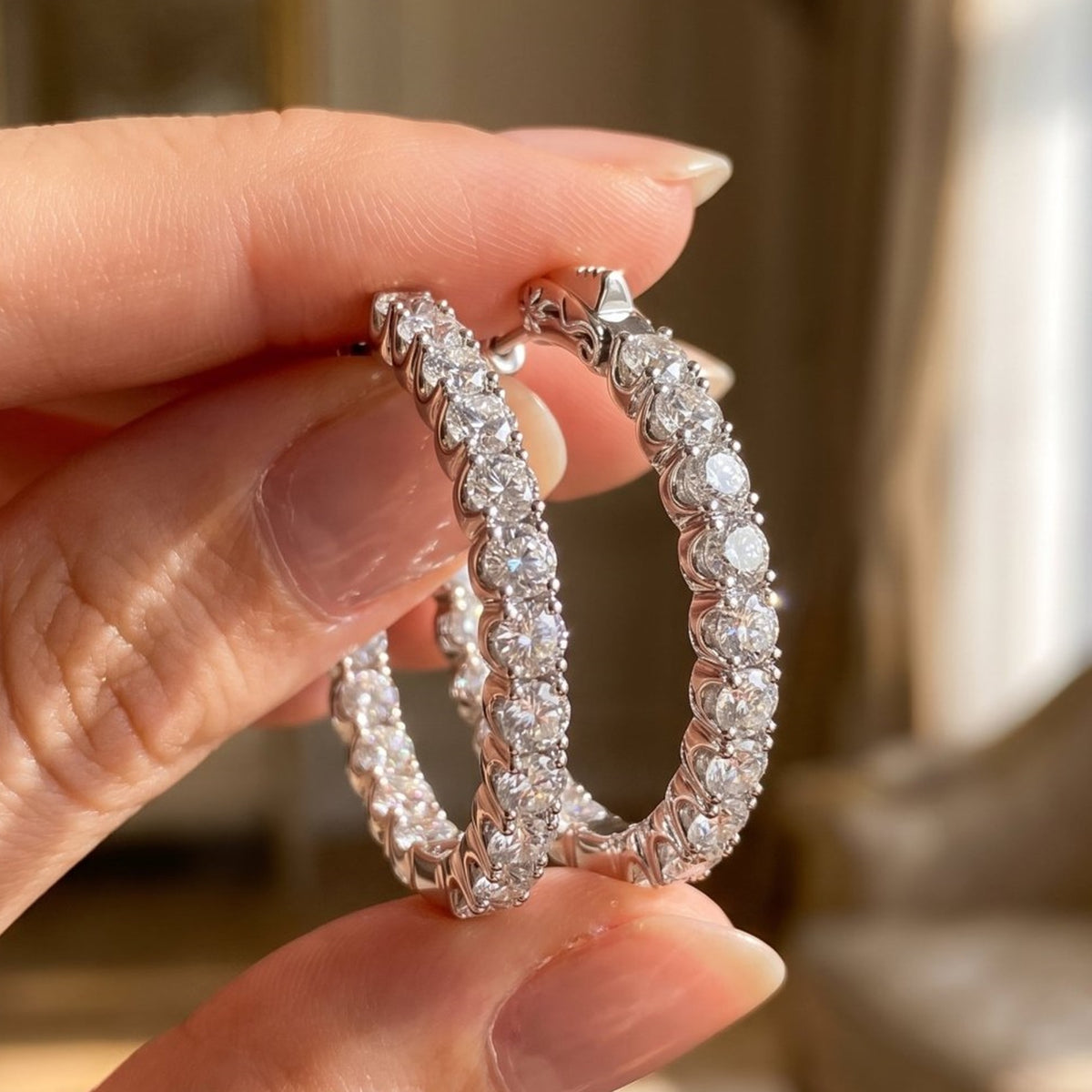 Lab-grown diamond hoop earrings in sterling silver, held in hand, close-up