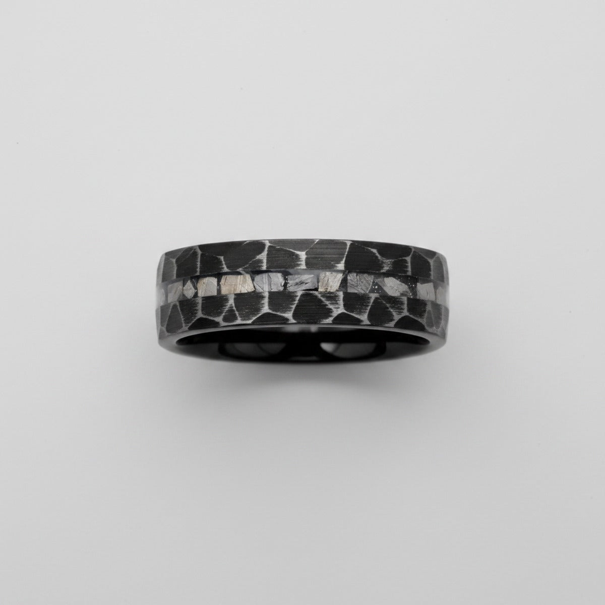 FISSURE black tungsten ring top-down view showing hammered finish and meteorite inlay