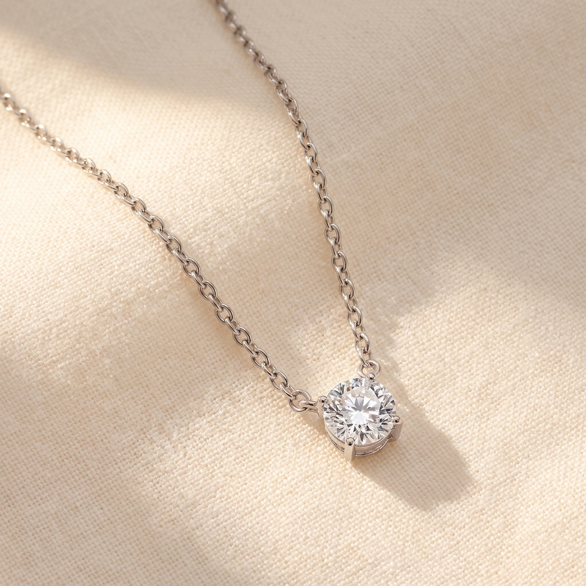 Four Prong Round Diamond Solitaire Necklace 925 silver lab grown diamond necklace styled flat lay on cream linen