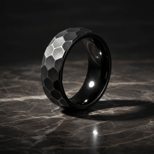 HEXANITE — Luxury 3/4 angle on dark marble — men's tungsten wedding ring.