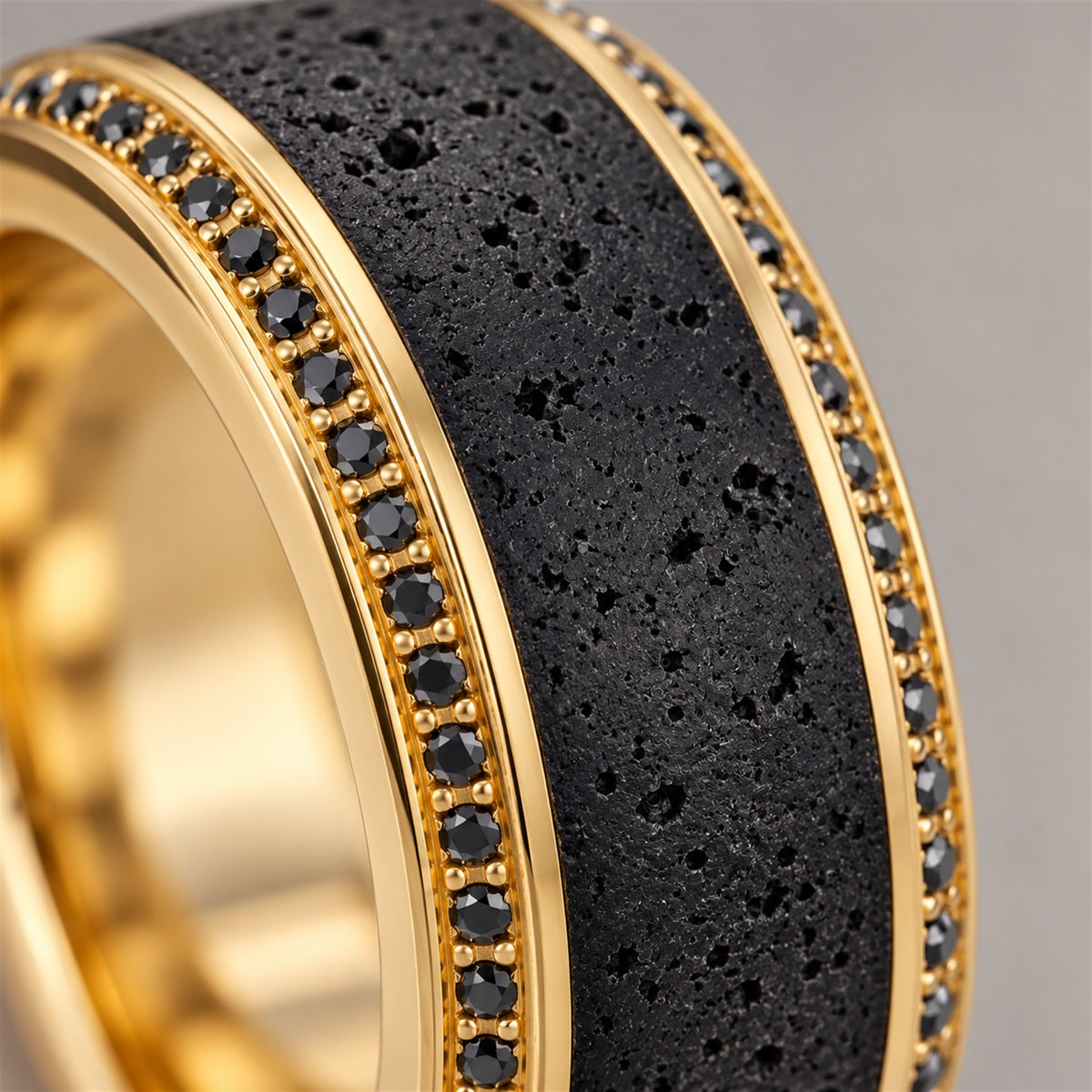 Close view of HYPERION lava texture, round black diamonds and polished yellow gold beveled edge