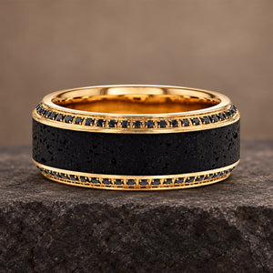 HYPERION 10mm lava and black diamond wedding band in yellow gold, front view on a stone ledge