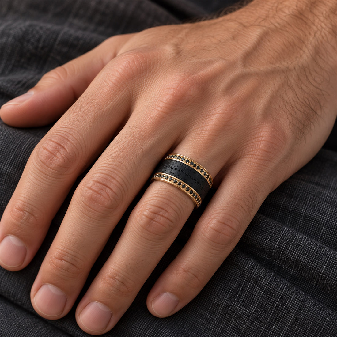 HYPERION 10mm yellow gold lava and black diamond wedding band worn on a man’s ring finger