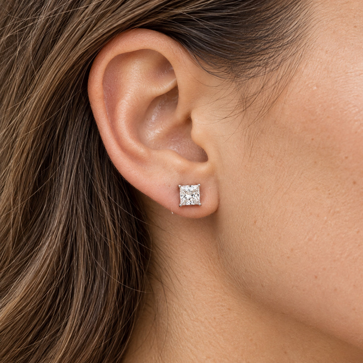Princess-cut lab-grown diamond stud earrings, worn on the ear, lifestyle photo