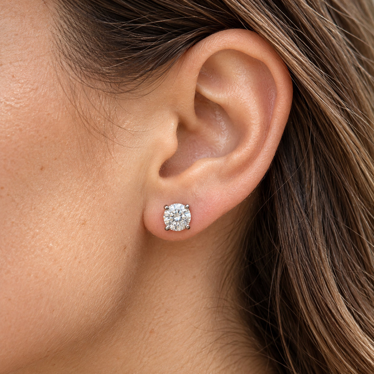 Round lab-grown diamond stud earrings, worn on the ear, lifestyle photo