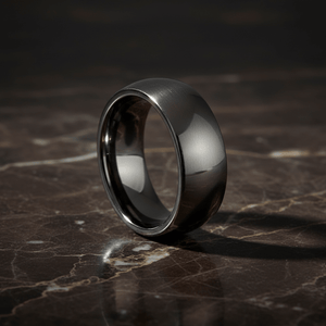 IVORY — Luxury 3/4 angle on dark marble — men's tungsten wedding ring.