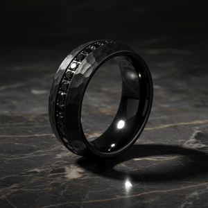 JUNCOS — Luxury 3/4 angle on dark marble — men's tungsten wedding ring.