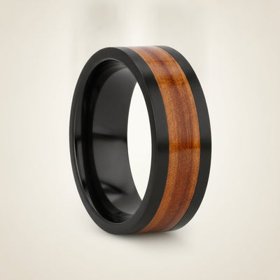 KALANI flat black tungsten carbide wedding band with koa wood inlay running around the band and polished edges, studio hero shot