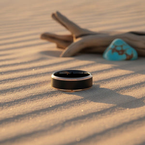 Aydins LEONARDO | Black Tungsten Brushed Center Rose Gold Stepped Edge Wedding Ring 8mm lifestyle scene, desert dune