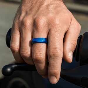 Close-up of domed surface on blue tungsten ring on middle finger hand