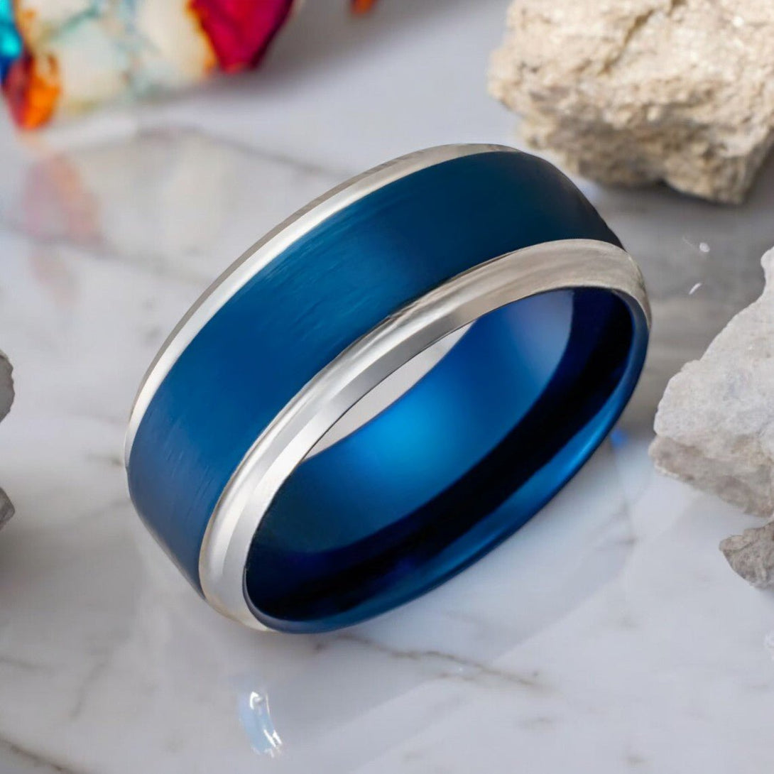 Close-up of LINARD tungsten ring showcasing brushed blue finish and silver stepped edge.