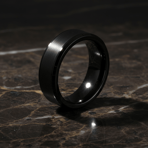 LOVELL — Luxury 3/4 angle on dark marble — men's tungsten wedding ring.
