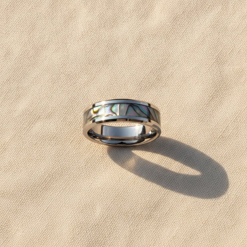 MAUI silver tungsten wedding band with iridescent mother of pearl inlay running around the band and polished edges macro detail overhead flat lay