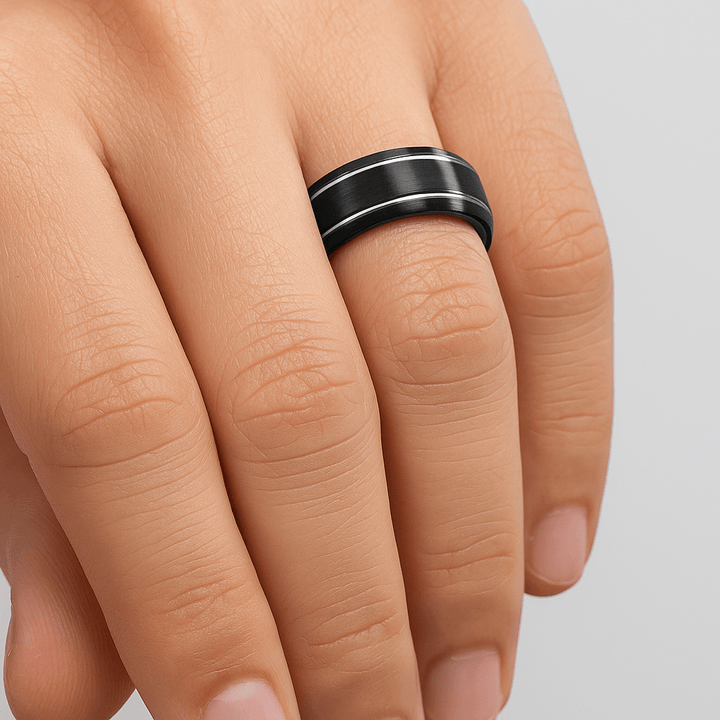NOCTURNE Black Tungsten ring on a person's finger against a neutral background